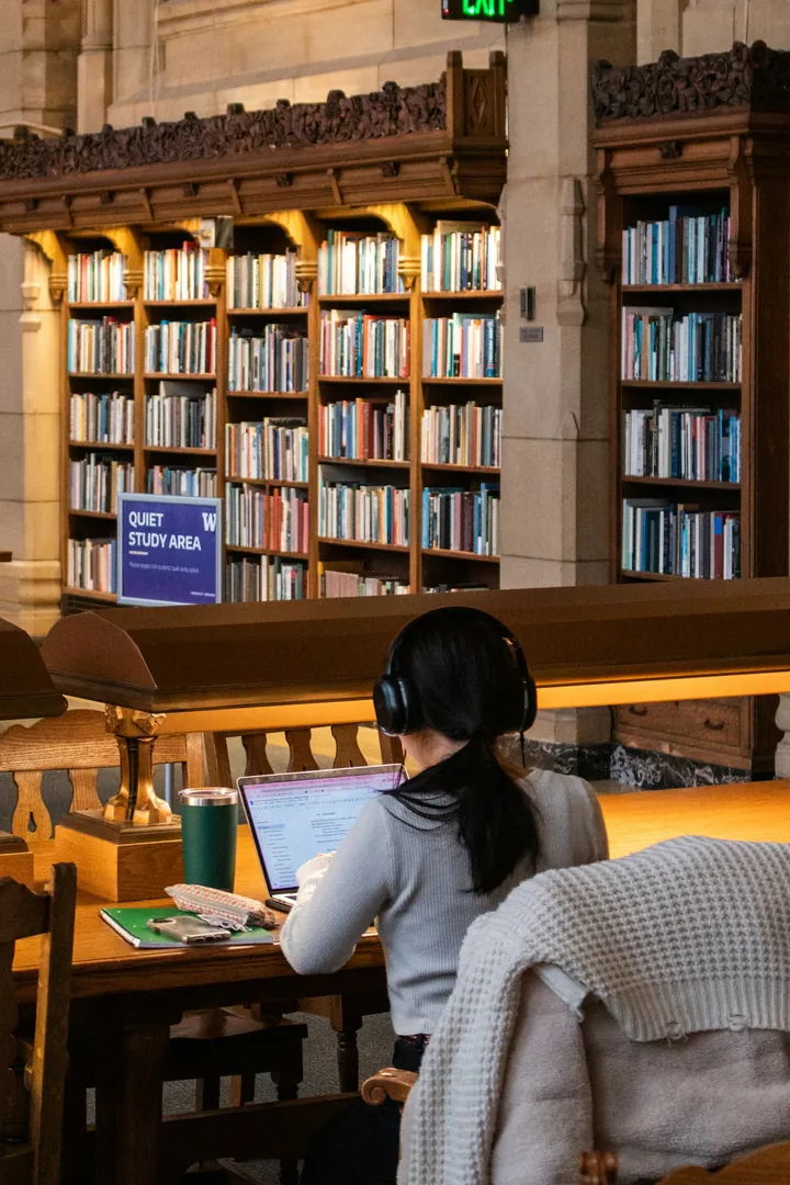 Une chercheuse en bibliothèque, devant son ordinateur