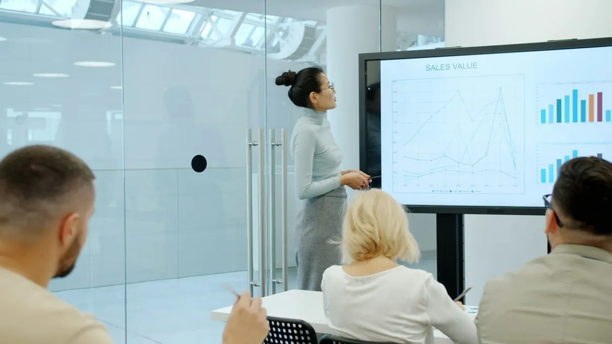 Une femme présente des graphiques à son équipe